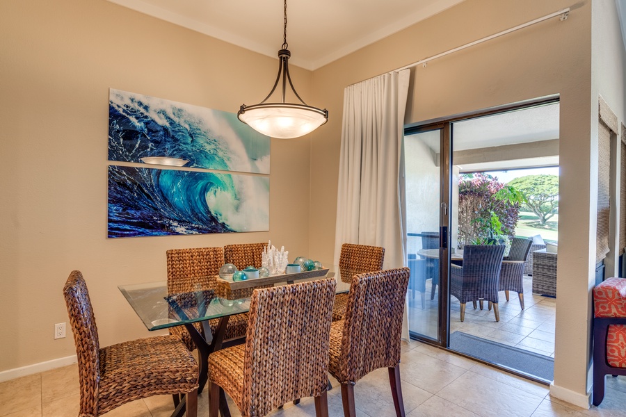 Dine in a vibrant setting accented by ocean-inspired art, where the glass table reflects the joy of shared meals and stories.