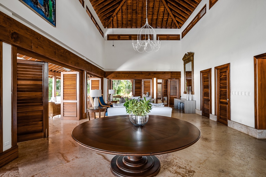 The living area offers high-vaulted ceiling and walls that opens to the patio.