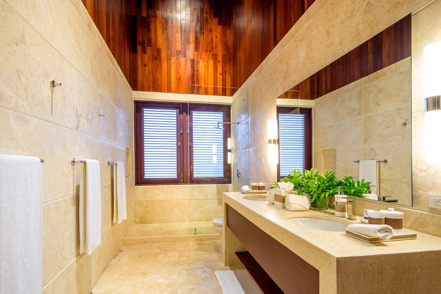 Full ensuite bathroom with a sleek design and large mirror.