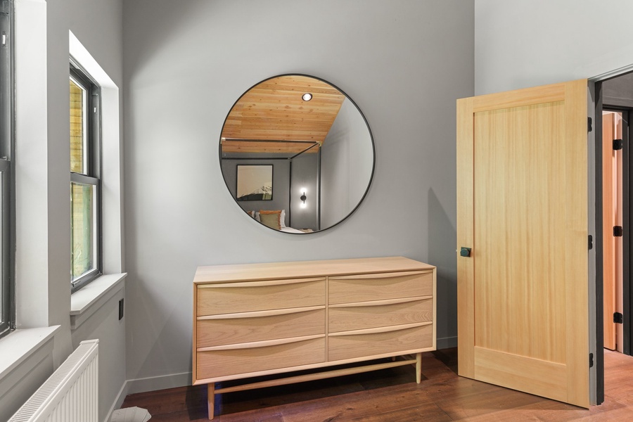 Convenience in our guest suite, featuring drawers for your belongings and a round mirror for those finishing touches.