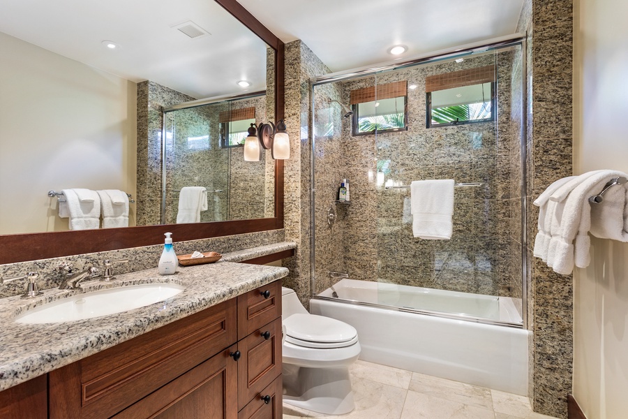Second full bathroom, en suite, with elegant granite and shower/tub combo.
