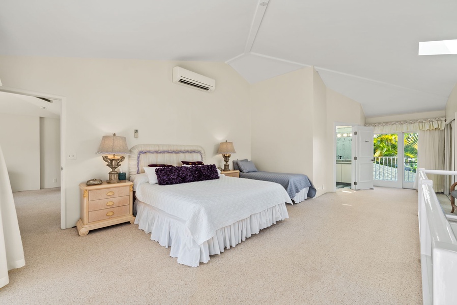Spacious second guest suite with a king and a twin bed and a skylight, filling the room with soft, natural light for a peaceful ambiance.