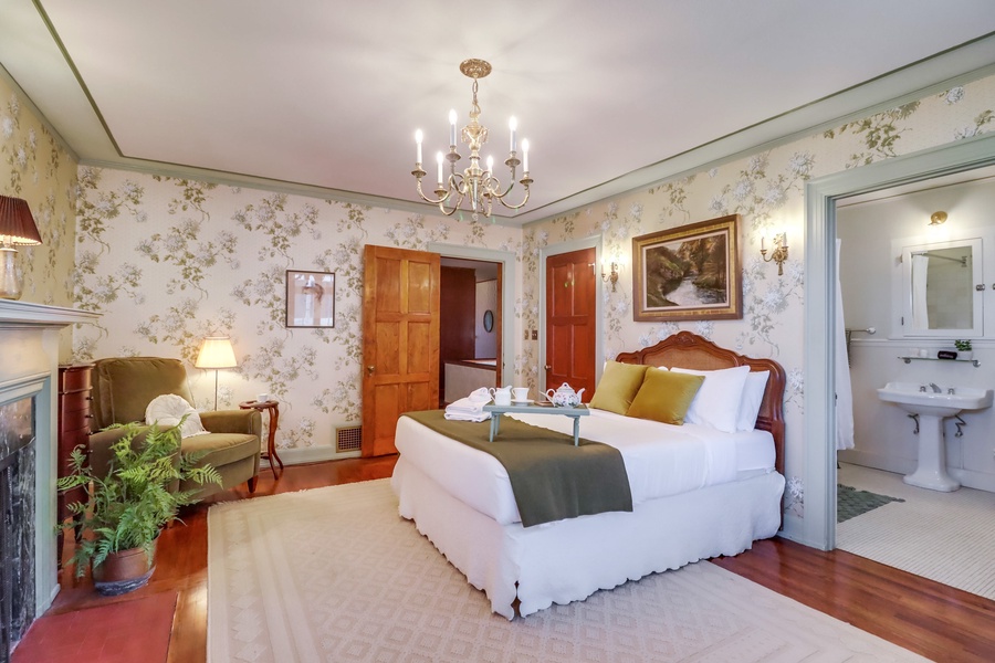 Escape upstairs to the elegance of guest room suite 1, where a king-sized bed, cozy fireplace, and private ensuite bathroom offer the ultimate in comfort, all enhanced by the vintage charm of antique candelabras casting a warm, romantic glow.