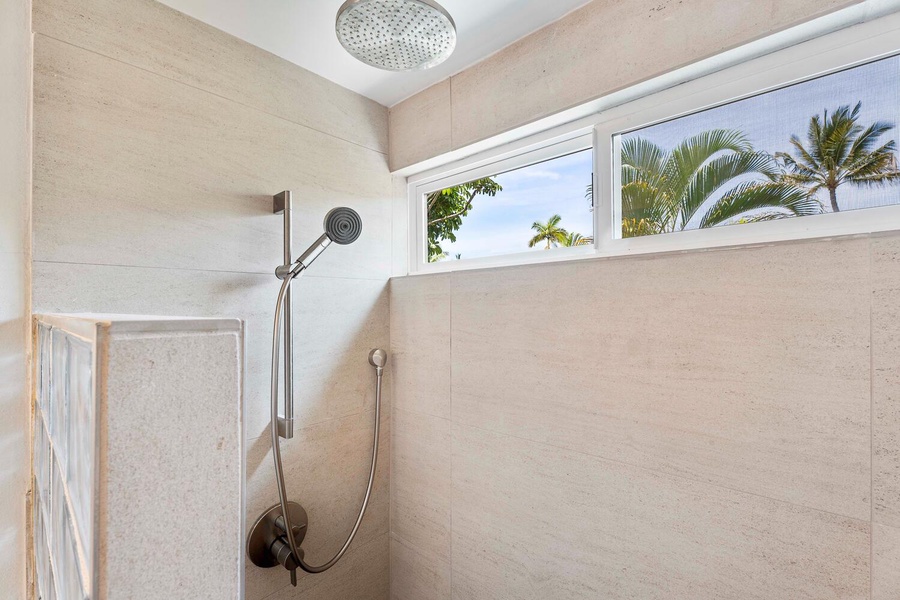 The glass-enclosed walk-in shower with natural lighting.