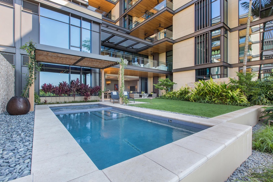 Modern apartment complex featuring a pristine pool area with tropical landscaping and contemporary architecture.