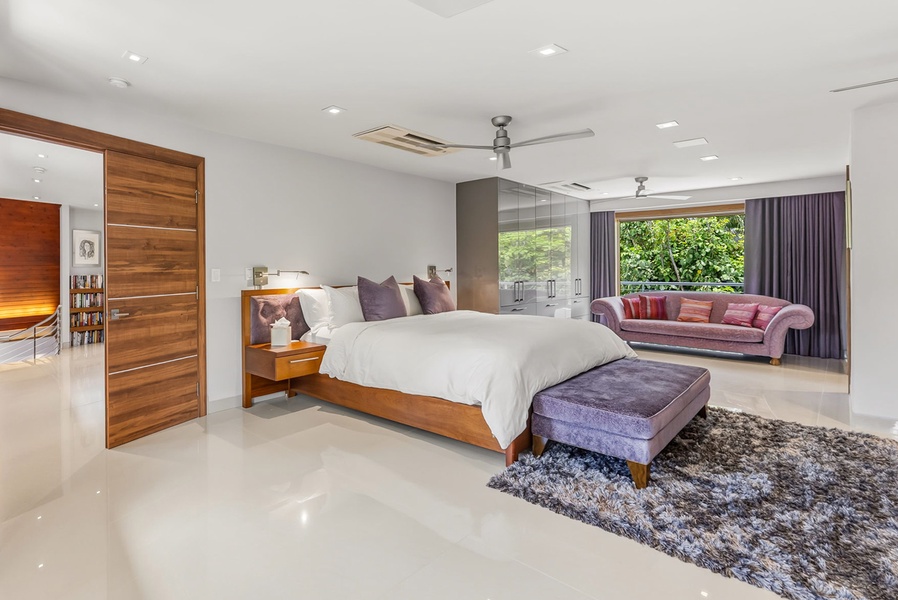 Sink into a plush king bed with crisp linens, unwind on the velvet sofa, and wake to lush garden views through floor-to-ceiling windows—your serene retreat awaits.