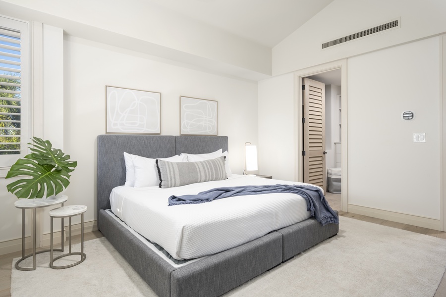 Sink into crisp white linens on your plush gray twin-converted-to-king bed, surrounded by modern coastal elegance and tropical touches.