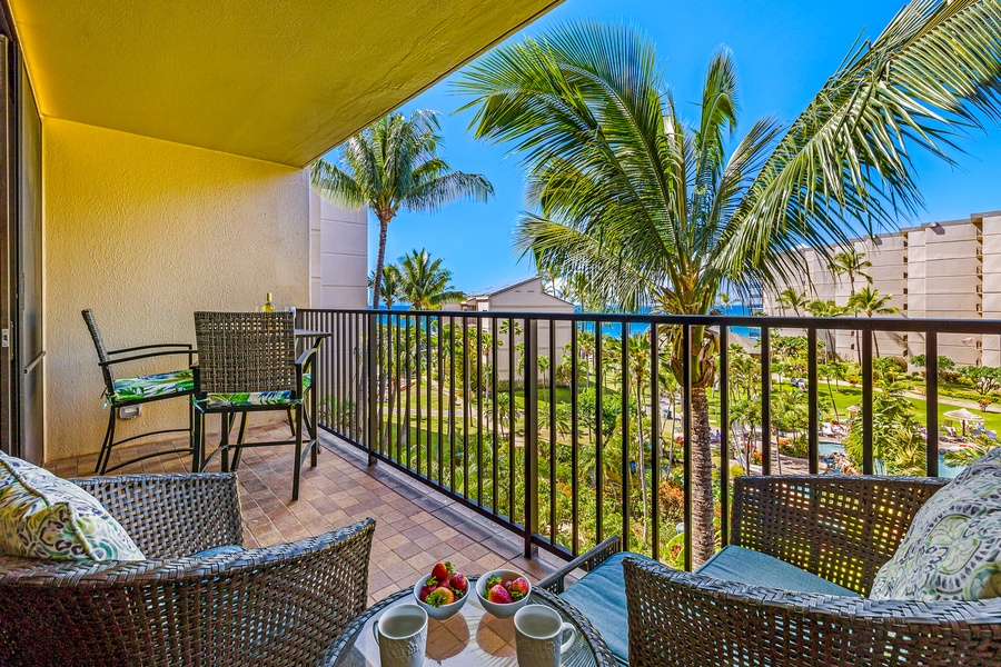 Relax on the private lanai, enjoying a morning coffee while taking in the serene views of lush palm trees and the sparkling ocean beyond.