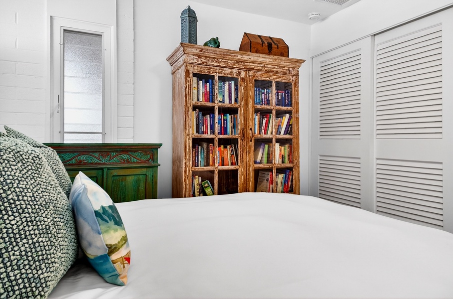 Curl up with your favorite book in this charming bedroom featuring a rustic wooden bookcase filled with literary treasures.