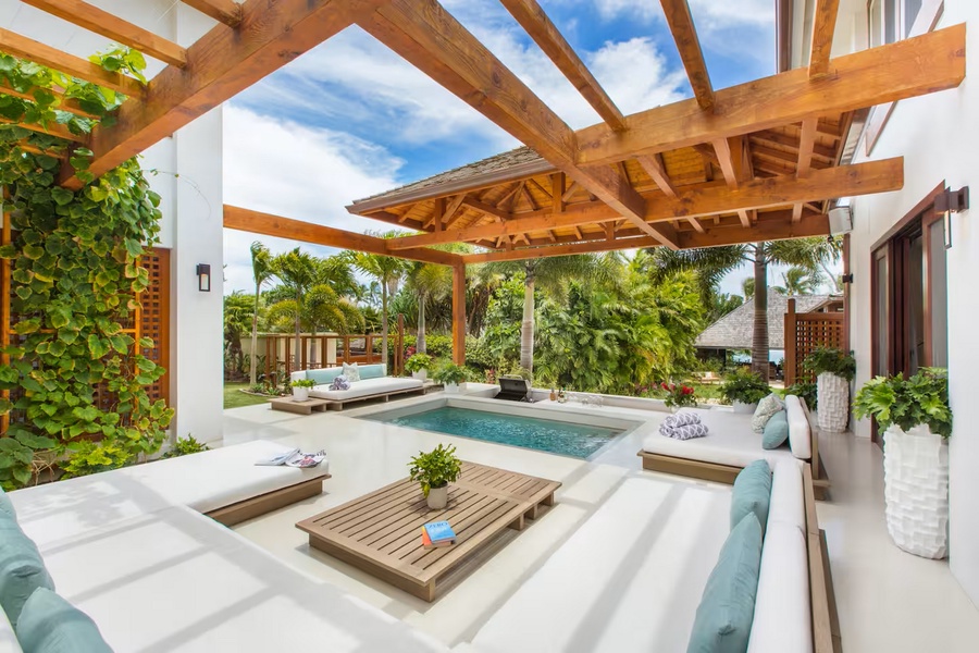 A daybed at the pool's edge under the palms, the afternoon already accounted for.