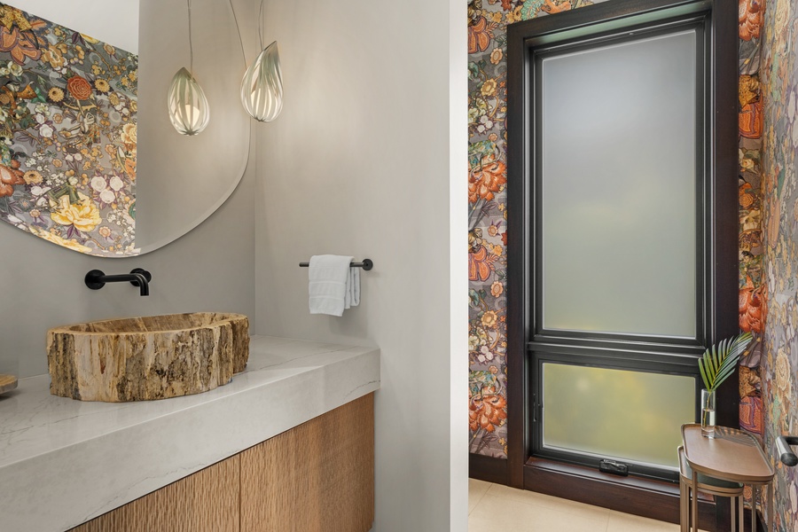 Step inside your stunning powder room featuring a unique live-edge wood sink, vibrant floral wallpaper, and elegant pendant lighting that creates pure luxury.