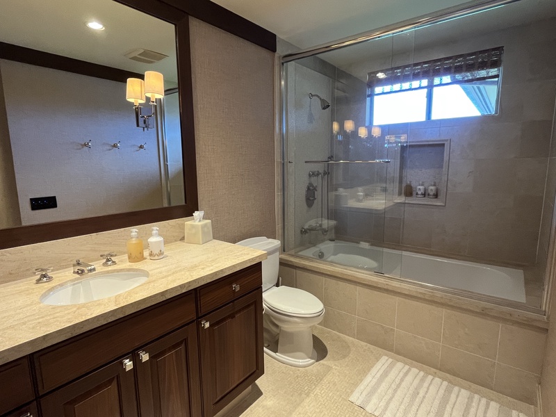 Third bath with shower-tub combo and polished vanity.