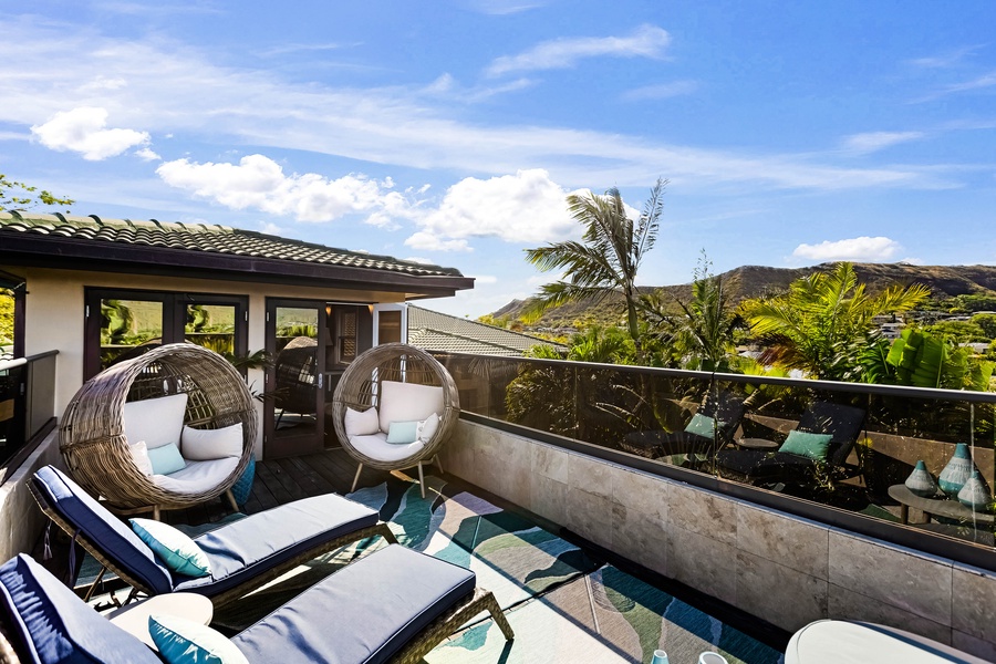 Circular loungers and palm trees on the upper-level terrace.