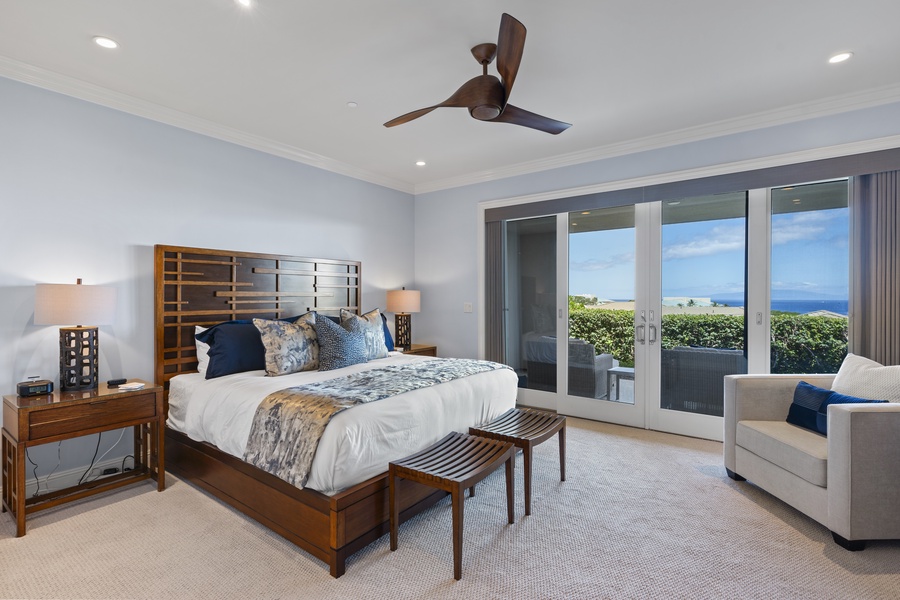 The primary suite offers a serene retreat with direct access to the lanai and breathtaking ocean views. The king-sized bed is complemented by luxurious linens and tasteful decor, creating a peaceful atmosphere for rest and relaxation.