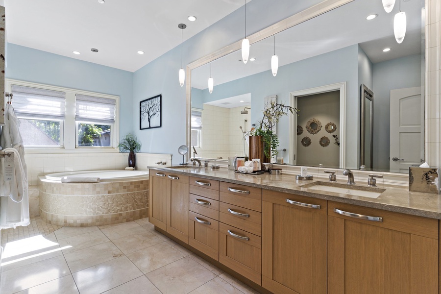 The ensuite bathroom has a soaking tub and two vanity spaces.