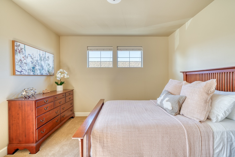 Experience comfort with well-appointed bedding, convenient nightstands, and a dresser in the third bedroom