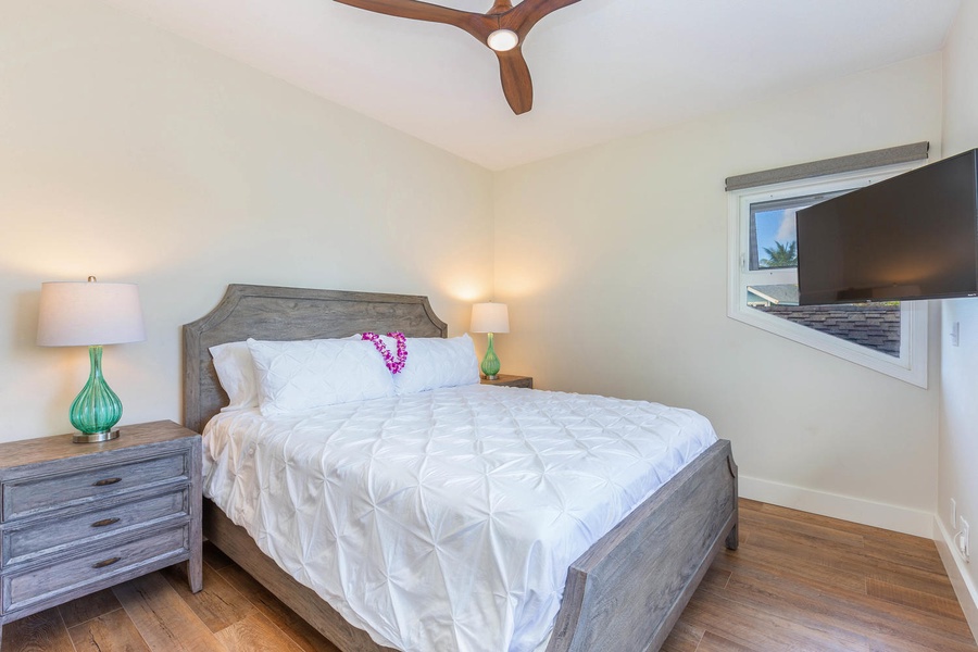 Guest bedroom at Pohaku Villa with a queen bed, air conditioning, and cozy atmosphere.