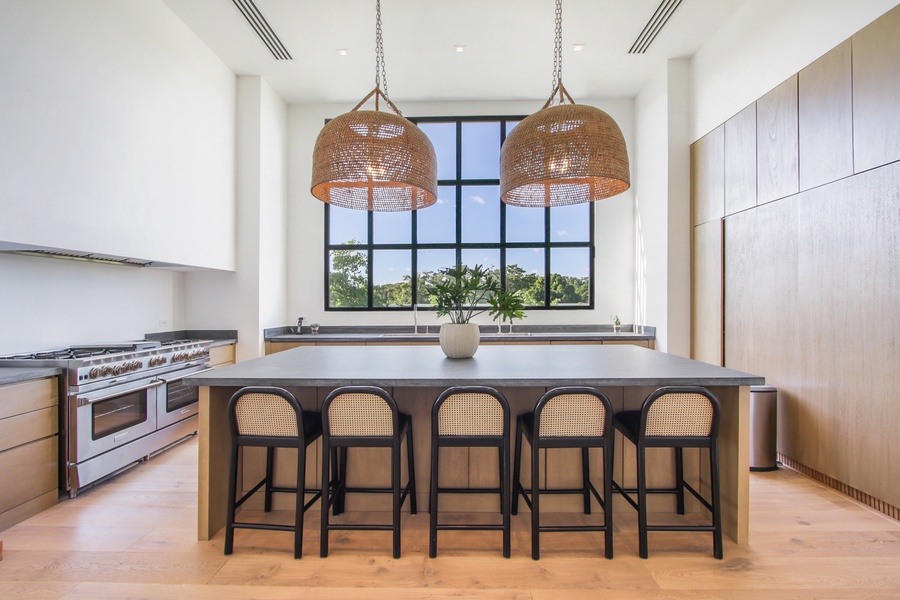 Enjoy cooking in the spacious kitchen with a large island and stylish hanging lights.