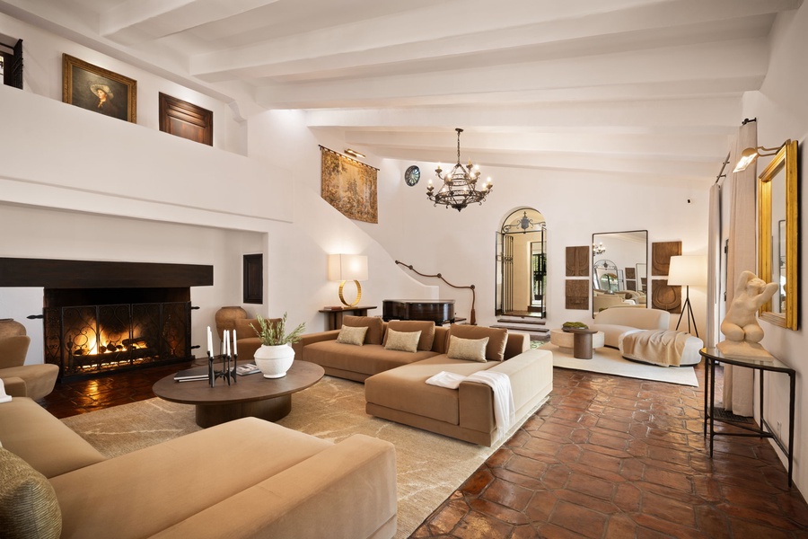 Unwind in this elegant living room where exposed beams meet modern comfort, with a crackling fireplace creating perfect ambiance.