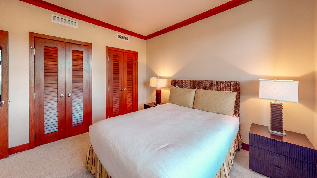 The second guest bedroom with closet space and night stand.