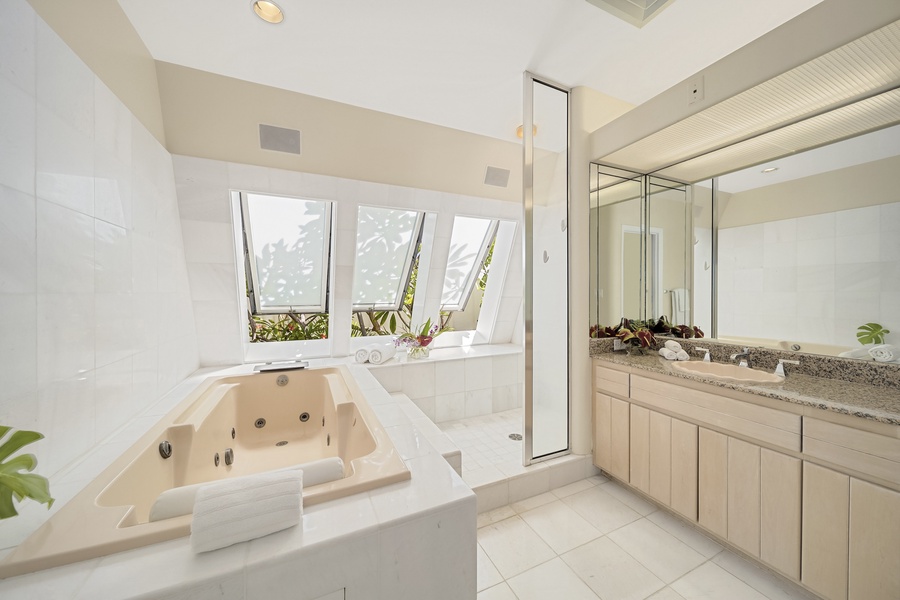 Primary bathroom with jetted tub and walk-in shower.