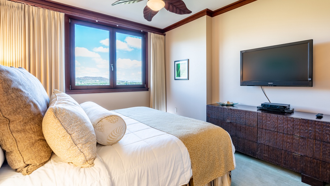 The primary guest bedroom featuring a TV and dresser.