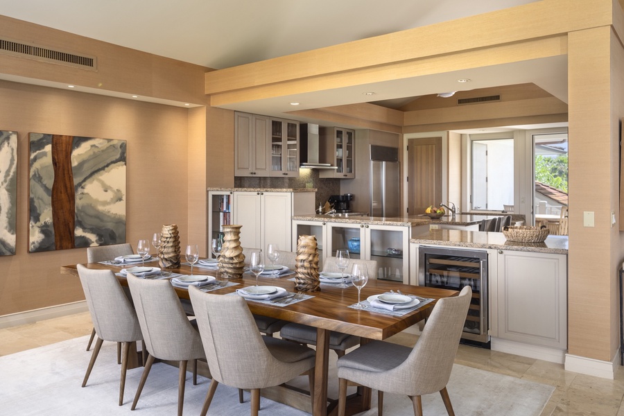 Wide view of the dining room into the kitchen, with an outdoor breakfast lanai beyond