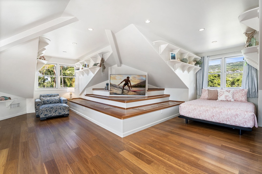 Your loft bedroom offers a cozy Queen beds and entertainment center with tropical views through bright windows.