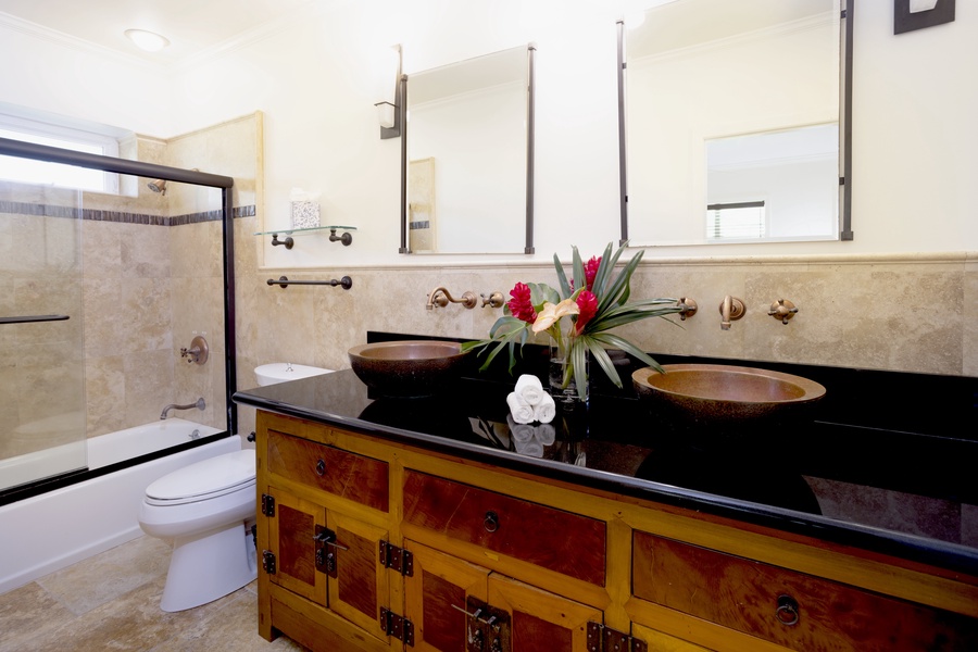 Ensuite bathroom with dual sinks and a shower/tub combo