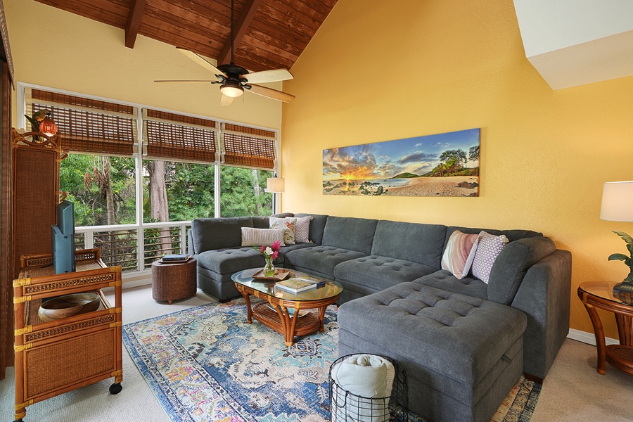 The living area greats you with a vaulted ceiling, and an airy and welcoming vibe with lots of outdoor views.