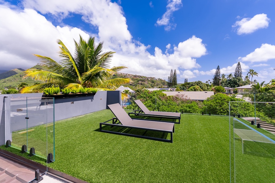Private lawn with loungers and elevated views over lush surroundings.