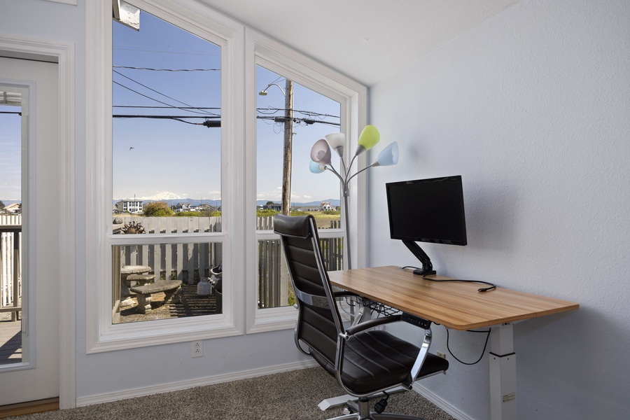 Comfortable desk setup with large windows for natural light and scenic productivity.