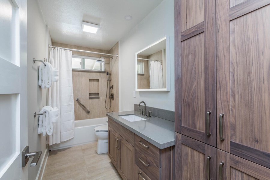 Lani Oasis guest bath featuring a walk-in shower, ample vanity space, and natural finishes.