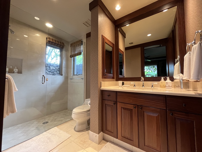 Ensuite bath with walk-in shower and rich wood cabinetry