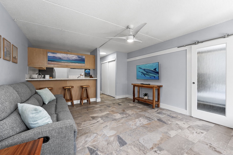 Open-plan living and dining area with stylish decor and tiled floors.