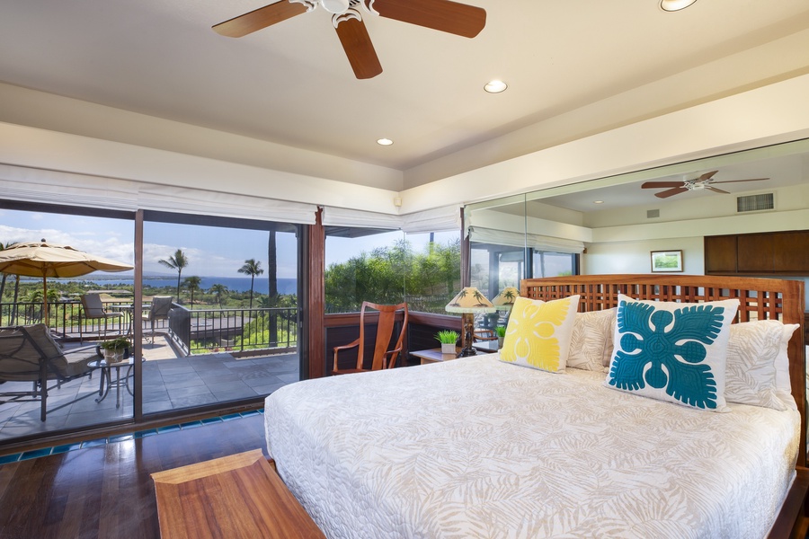 Serene primary bedroom with a king bed, private lanai access, and stunning coastal views.
