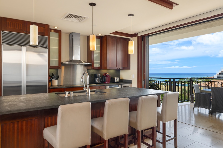 Step into your gourmet kitchen featuring sleek appliances and granite counters, where you'll love preparing meals while enjoying stunning ocean views.