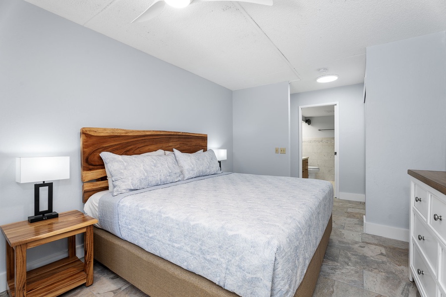Another angle of the bedroom showing ample space and warm tones.