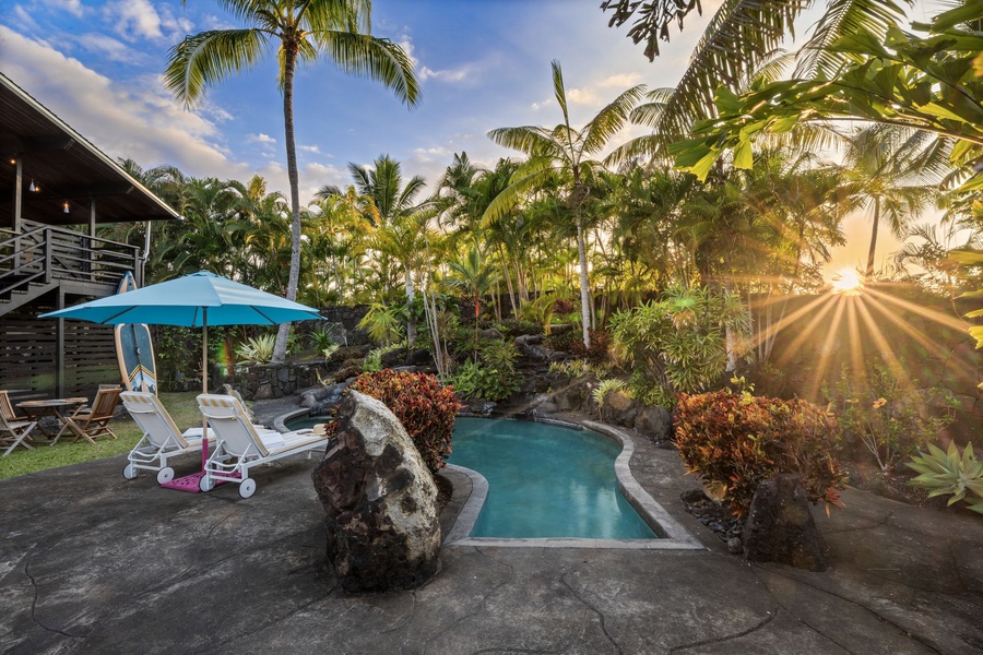 Your private tropical oasis awaits with a stunning rock-lined pool surrounded by swaying palms and vibrant landscaping for ultimate relaxation.