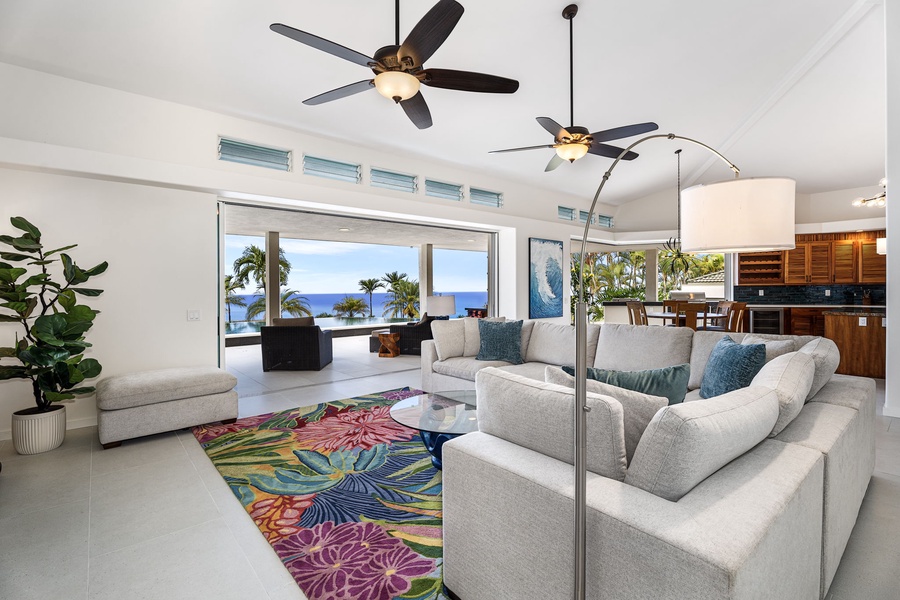 High ceilings and glass sliders create a breezy indoor-outdoor flow, where ocean views take center stage in the open-concept living area.
