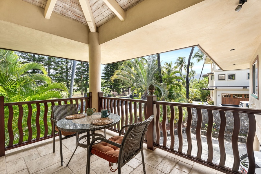 Covered media room lanai with tropical garden views—perfect for morning coffee or a quiet reading nook.