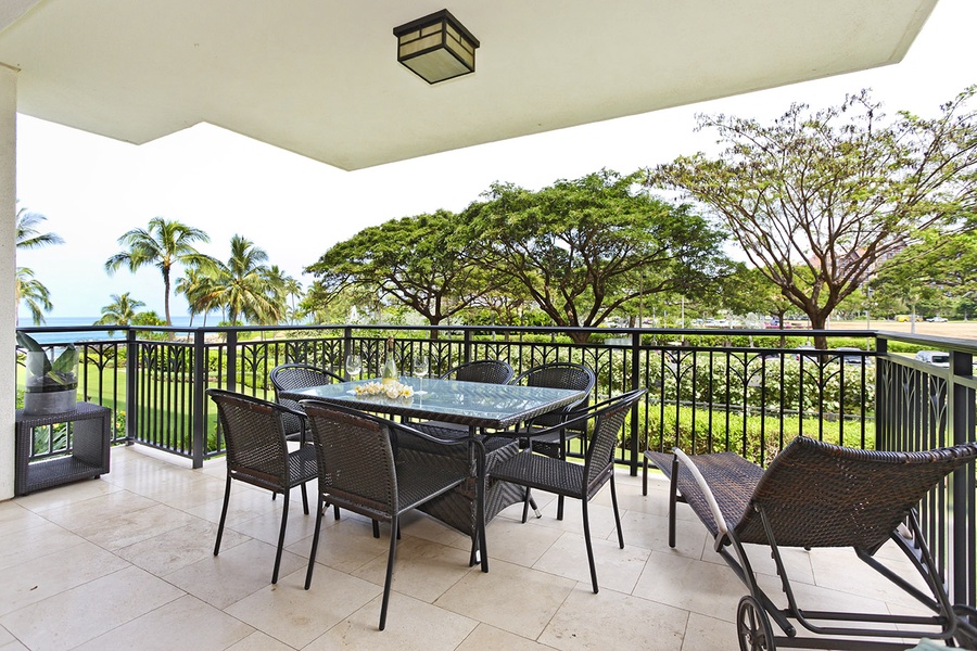 An expansive lanai surrounded by lush green trees.