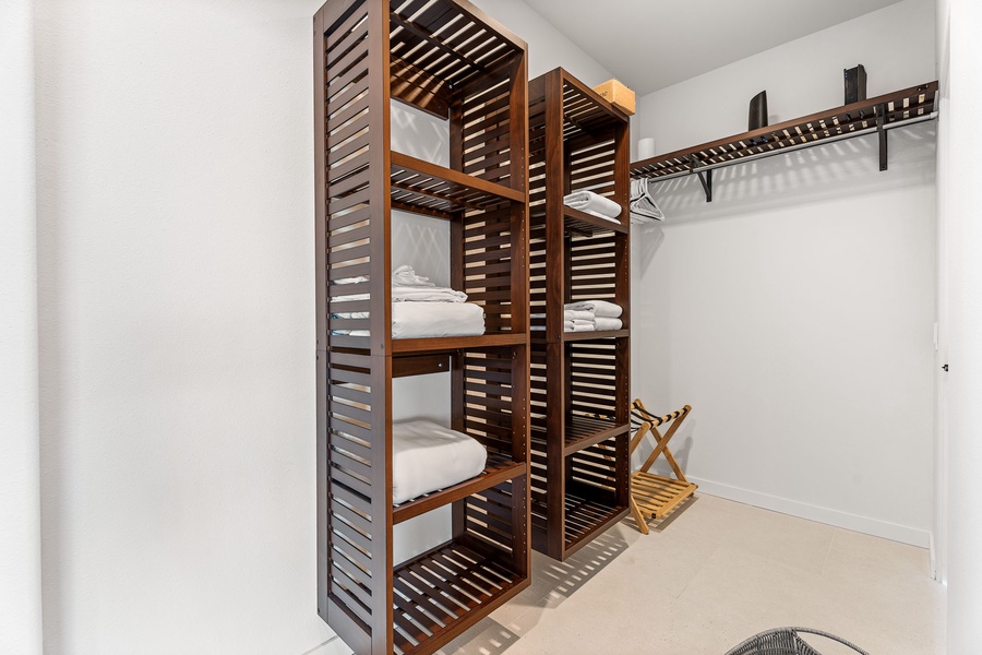Spacious walk-in closet with custom shelving and natural textures, offering resort-style convenience and ample storage.