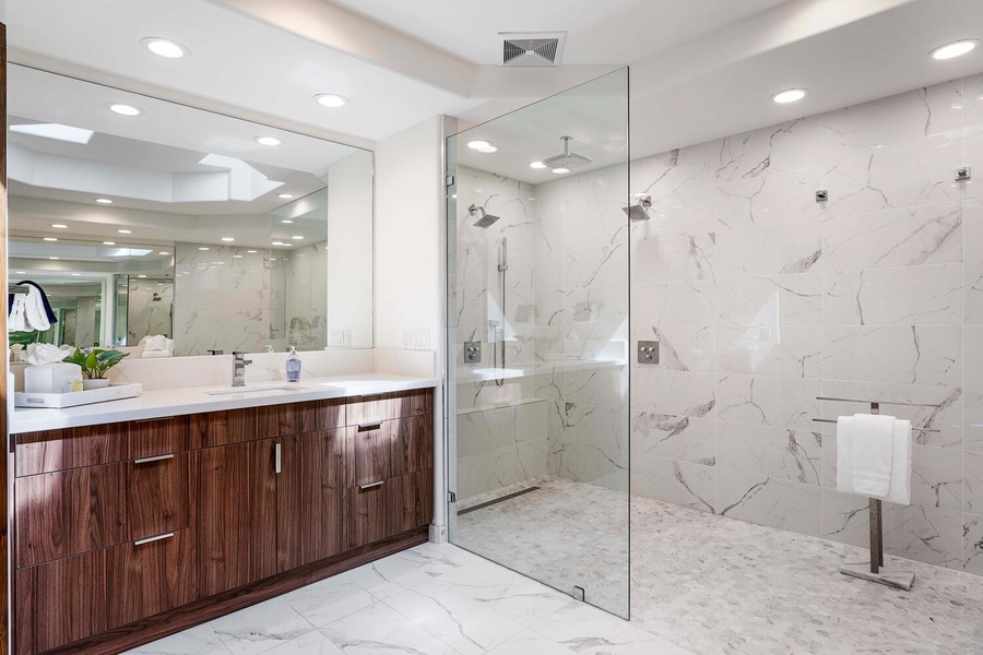 Spa-like ensuite with wide vanity space, natural stone finishes, and modern lighting.