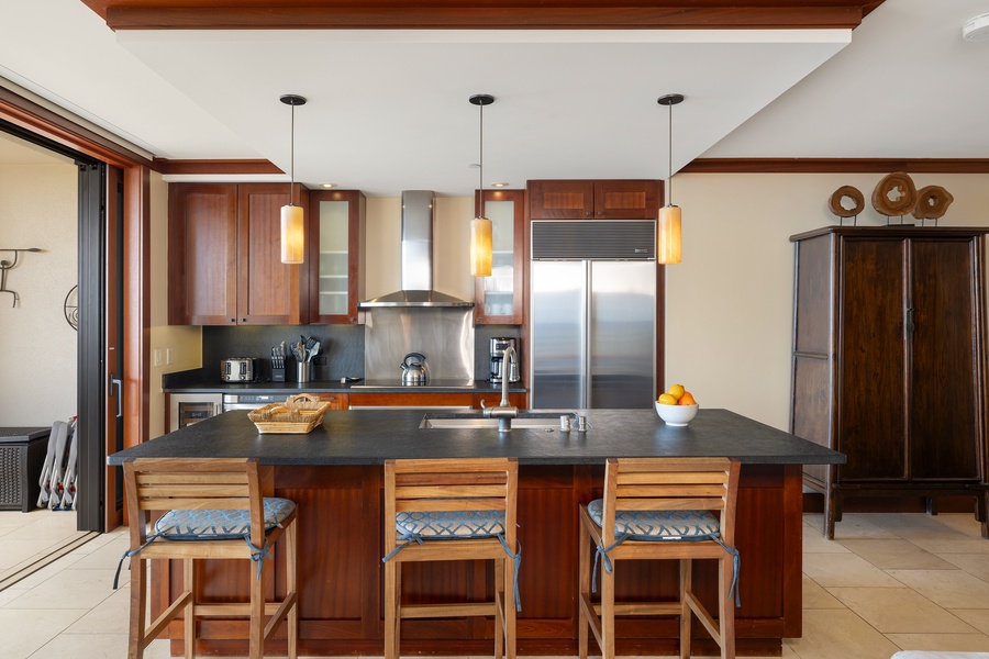 The kitchen features a large island with seating, perfect for casual meals and socializing.