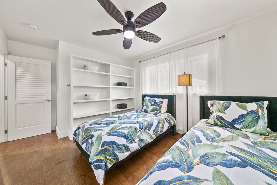 Third guest bedroom with two twin beds and an open closet.