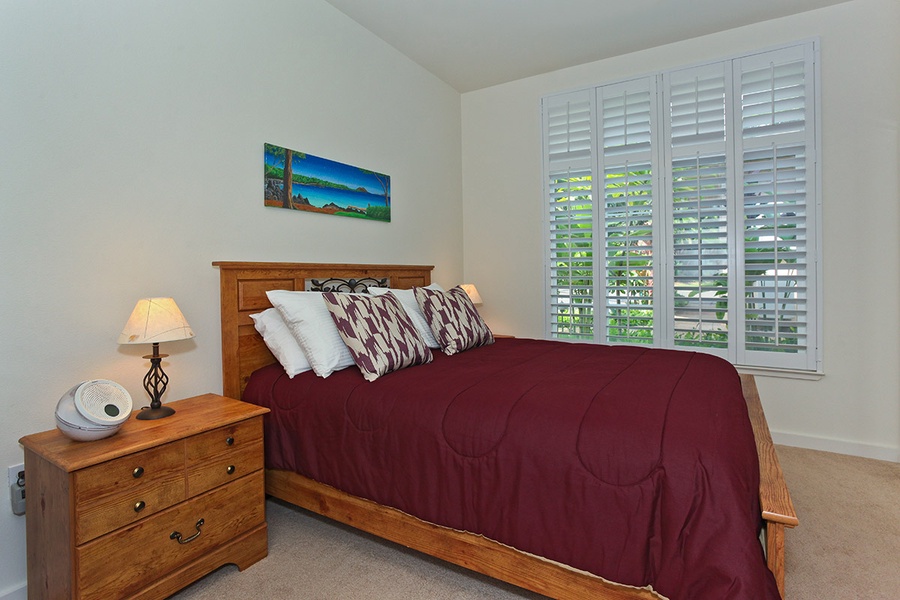 The second guest bedroom features natural light and soft bedding.