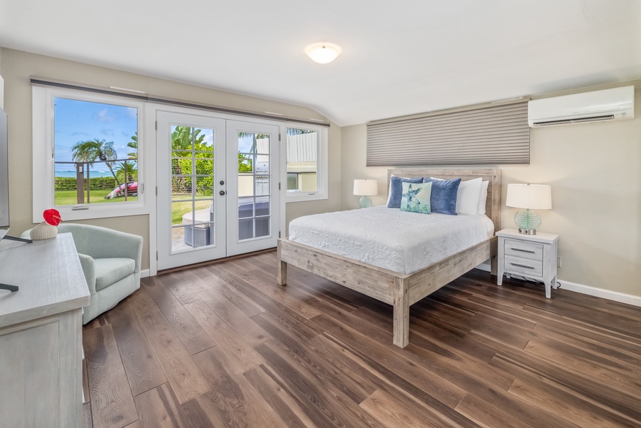 The secondary suite offers a queen-sized bed and doors leading to a private patio.