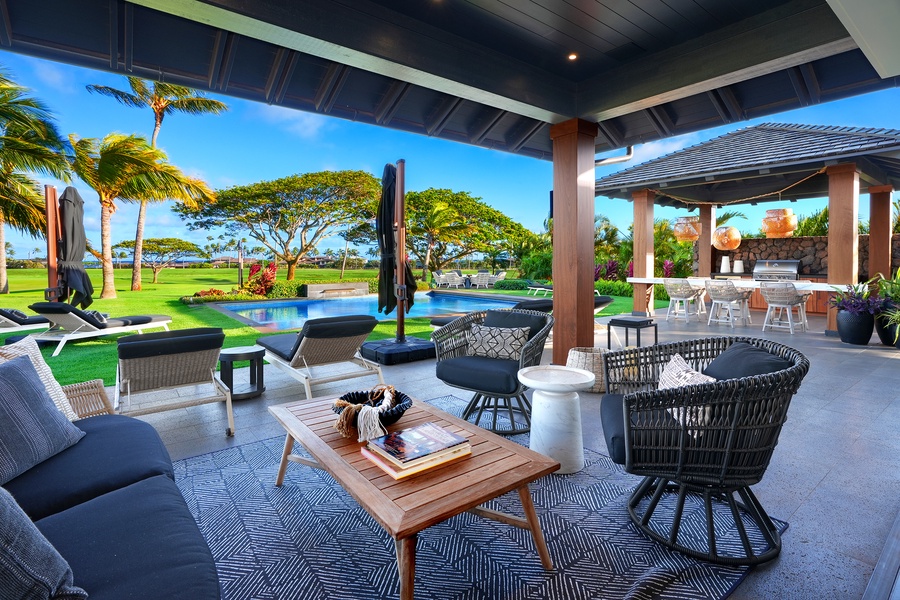 Lounge in comfort on the shaded lanai with ocean views and a serene poolside setting.