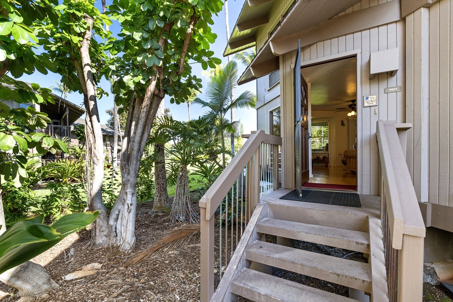 Tropical entrance surrounded by lush palms and greenery creates a peaceful island retreat atmosphere.